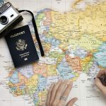 passeport et appareil photo posée sur une mappe monde